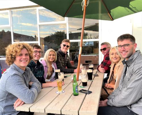 a group of people sitting at a picnic table at Atlantic Apartotel in Bundoran