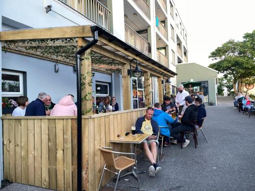 a group of people sitting at tables outside a restaurant at Atlantic Apartotel in Bundoran