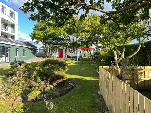 a yard with a playground and a fence at Atlantic Apartotel in Bundoran