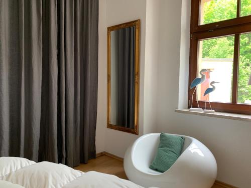 um quarto com uma cadeira branca em frente a uma janela em Auf der Zschopau-Insel em Zschopau