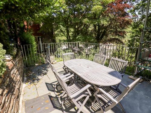 a wooden table and chairs with a fence at Lewarne in Boscastle