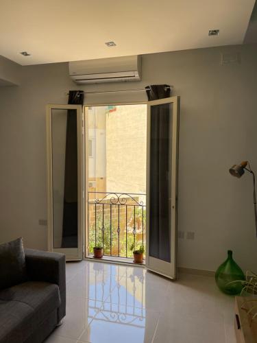 a living room with a sliding glass door with a balcony at Sunset Modern Apt near the beach in Birżebbuġa