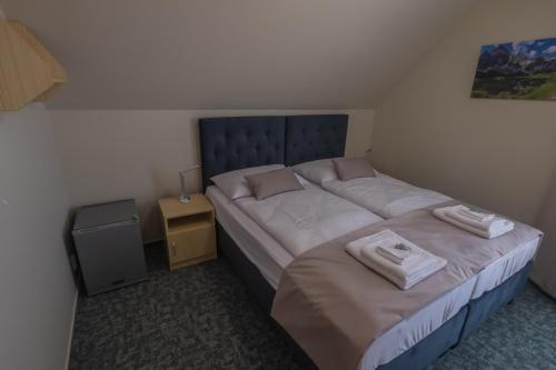 a small bedroom with a bed with two towels on it at Penzion Rysy in Veľká Lomnica