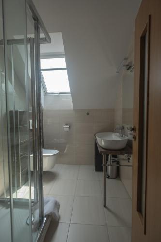 a bathroom with a glass shower and a sink at Penzion Rysy in Veľká Lomnica