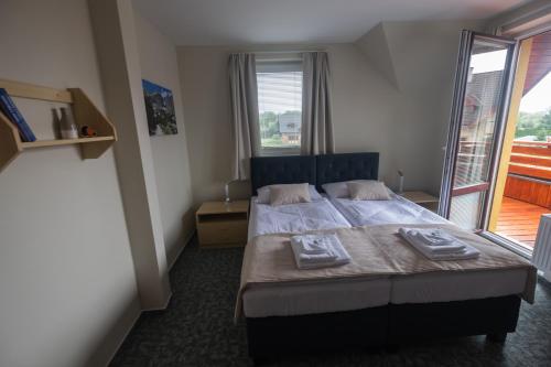 a bedroom with a bed with two towels on it at Penzion Rysy in Veľká Lomnica