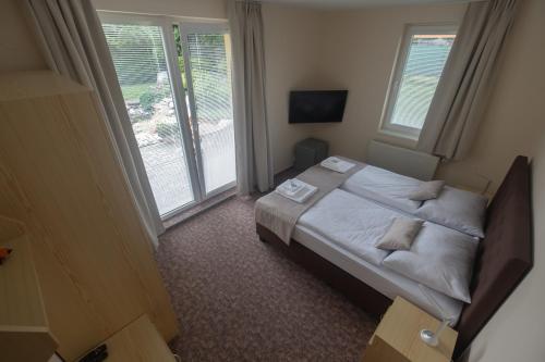a small bedroom with a bed and a window at Penzion Rysy in Veľká Lomnica