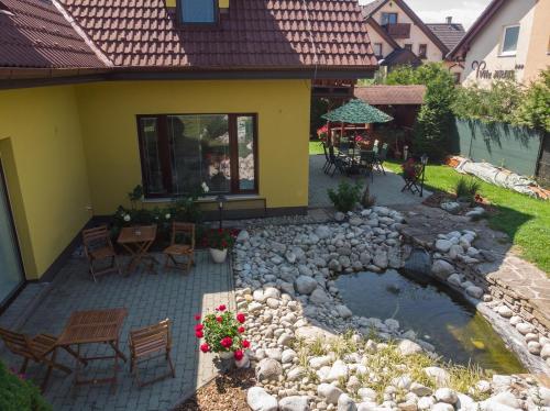 a patio with a pond in front of a house at Penzion Rysy in Veľká Lomnica