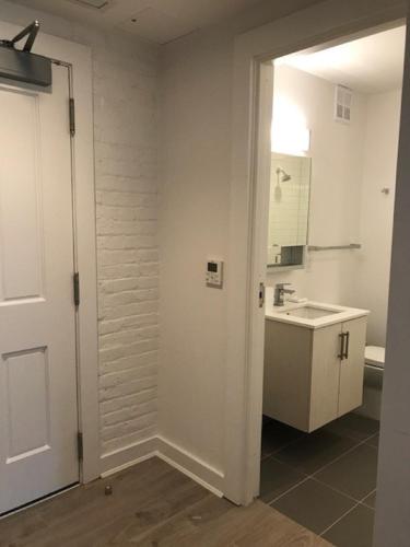a white bathroom with a sink and a mirror at Placemakr Dupont Circle in Washington