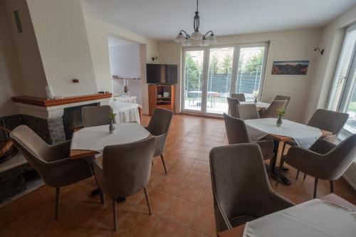 a dining room with tables and chairs and a fireplace at Penzion Rysy in Veľká Lomnica