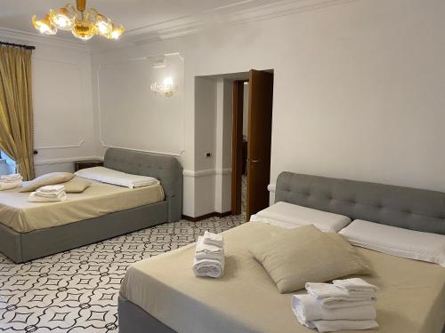 Un dormitorio con dos camas y una lámpara de araña. en Eliceto Resort & SPA, en Buccino