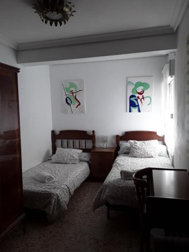um quarto com 2 camas e um lustre em Anahouse em Alcalá de Henares