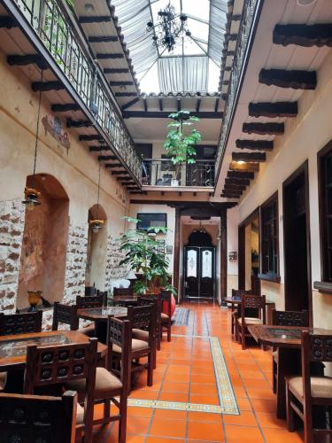 um restaurante com mesas e cadeiras de madeira e um tecto em La Posada Cuencana Hotel Boutique em Cuenca