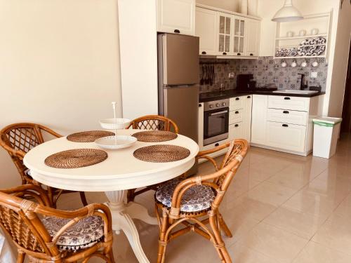 a kitchen with a table with chairs and a refrigerator at Goldfish Seaside Luxury Houses in Kómi