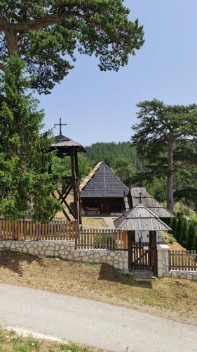a building with a fence and a church at Miliceva ruza in Zlatibor