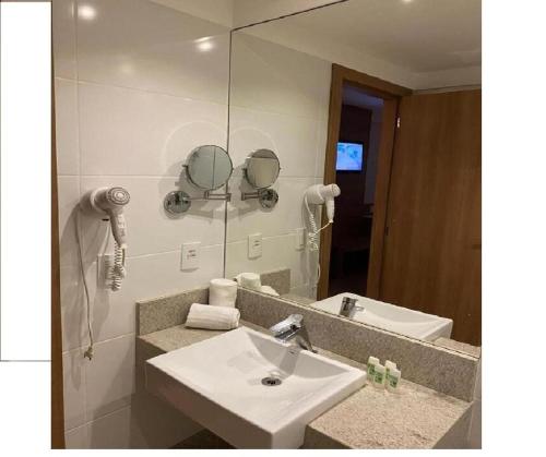 un bagno con lavandino e specchio di Condominio Vista azul Flat-Hotel a Pedra Azul