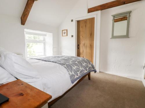 a bedroom with a bed and a window at Kerslake Cottage in Bodmin