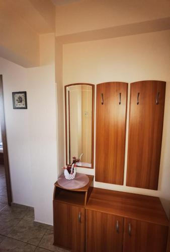 a bathroom with wooden cabinets and a mirror at Casa Laura in Mangalia