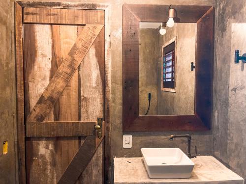 a bathroom with a wooden door and a sink at 3 Piratas in Prea