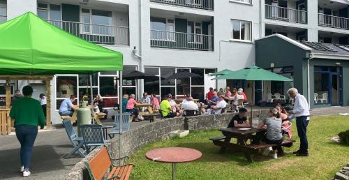a group of people sitting at tables under a green tent at Atlantic Apartotel in Bundoran
