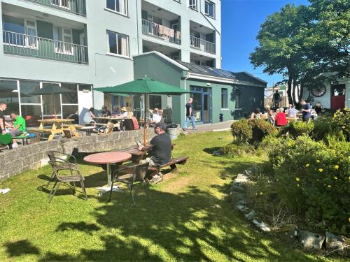 a man sitting at a table in a garden at Atlantic Apartotel in Bundoran