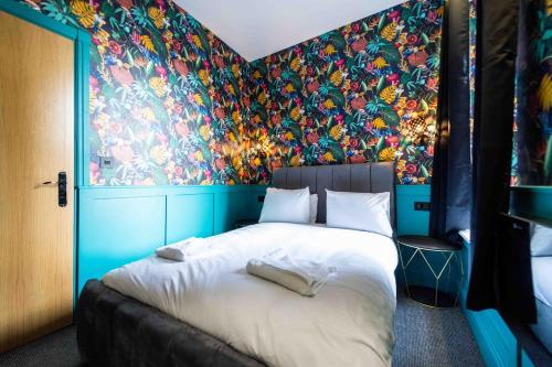a bedroom with a large bed with a colorful wall at Luxury Blackpool Apartments by Sasco in Blackpool