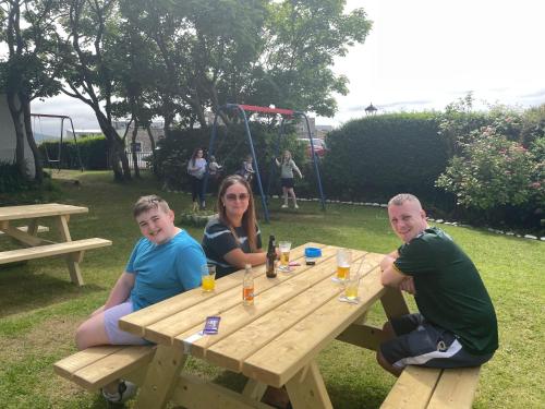 a group of people sitting at a picnic table at Atlantic Apartotel in Bundoran