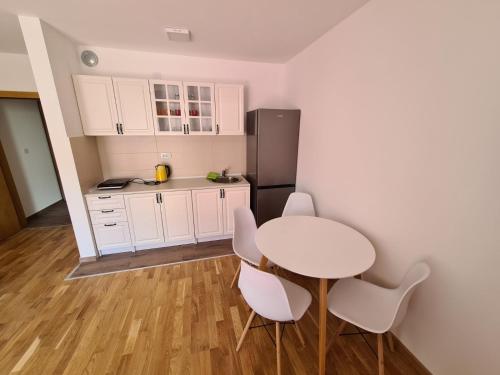 cocina con mesa, sillas y nevera en Apartman Jelena Sokobanja en Soko Banja