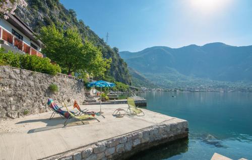 a group of chairs sitting on a dock next to a body of water at Apartmani Mrsic in Risan