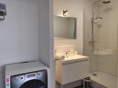 een badkamer met douche en wastafel en een wasmachine bij Appart'HomeCity - Rouen Grand Prieuré in Rouen