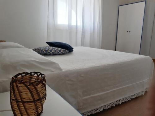 a white bed with a basket on top of it at Casa tra Cielo e Mare in Lipari