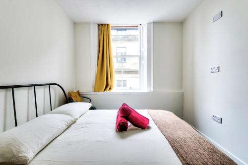 a pair of red shoes sitting on top of a bed at Haystack Hostel in Edinburgh