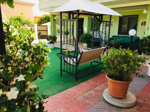 a patio with a chair and an umbrella and plants at La Dea Hestia in Bosa