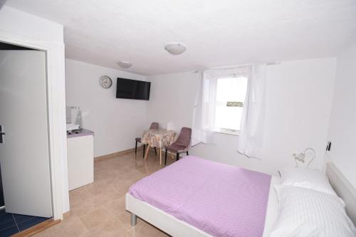 a bedroom with a bed and a window and a table at Apartmani Mihaela in Šibenik