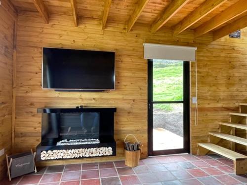 a room with a fireplace and a flat screen tv at Altozano Cabañas in Guatavita