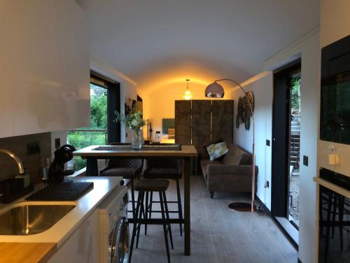 a kitchen with a counter and a bar with stools at Vagón Orient Express - Housevanlive in Casas Altas