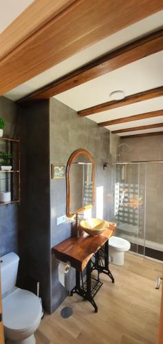 a bathroom with a wooden table and a mirror at Vivienda María Lourdes in Brion