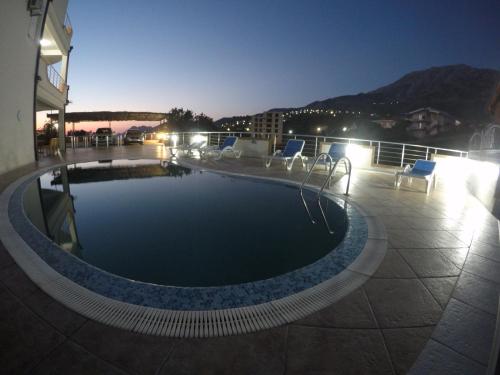 una piscina en la parte superior de un edificio por la noche en Belvedere Apartments with Seaview, en Dobra Voda