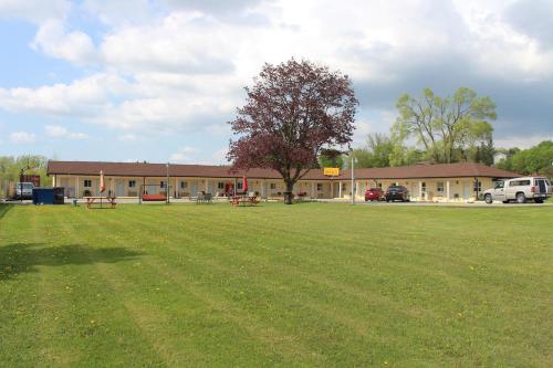 a large grass field in front of a building at Budget Inn in Port Hope