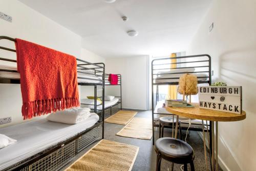 a dorm room with bunk beds and a table at Haystack Hostel in Edinburgh