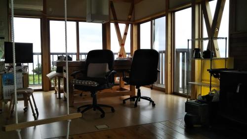 an office with two chairs and a desk with windows at Nihonkai Nou no yado Miharashitei - Vacation STAY 11631 in Itoigawa