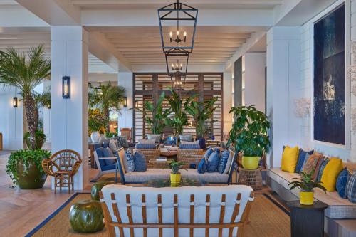 a lobby with couches and chairs and palm trees at The Seabird Ocean Resort & Spa, Part of Destination Hotel by Hyatt in Oceanside