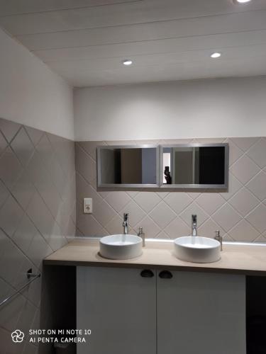 ein Badezimmer mit 2 Waschbecken und einem Spiegel in der Unterkunft les gites de la bouldoire Renaissance in Rignac