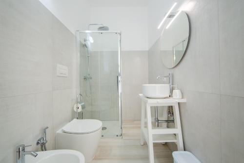 a bathroom with a toilet and a sink and a mirror at B&B SOLE in Torre San Giovanni Ugento