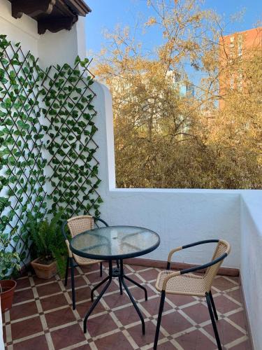 a glass table and two chairs on a patio at De Blasis Budget Rooms in Santiago