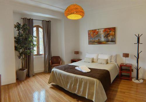 a bedroom with a bed, a table, and a painting on the wall at Hotel De Blasis & Cowork in Santiago