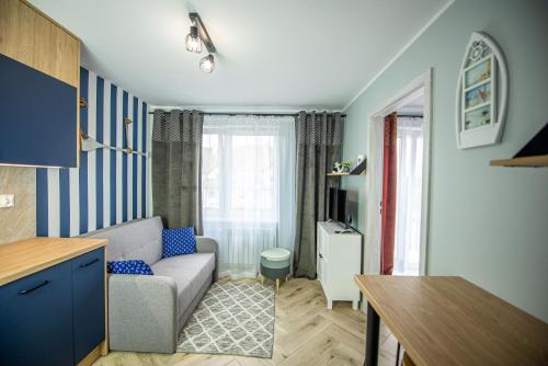 een woonkamer met een bank en een tafel bij Apartament Omega II in Giżycko