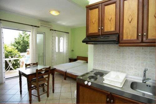 a kitchen with a room with a bed and a table at Dias Studios in Pythagoreio