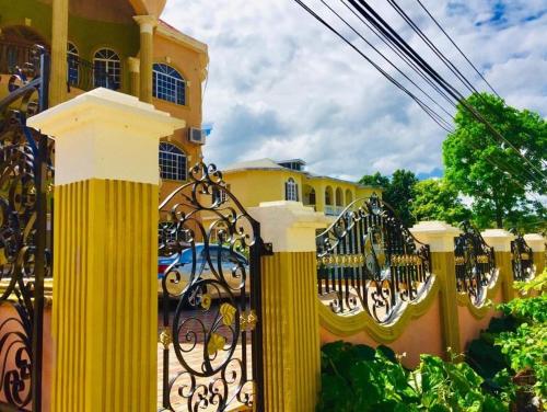 a yellow fence in front of a yellow building at Eagle's Nest in Montego Bay