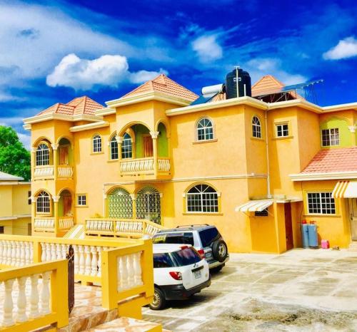 a yellow house with a car parked in front of it at Eagle's Nest in Montego Bay