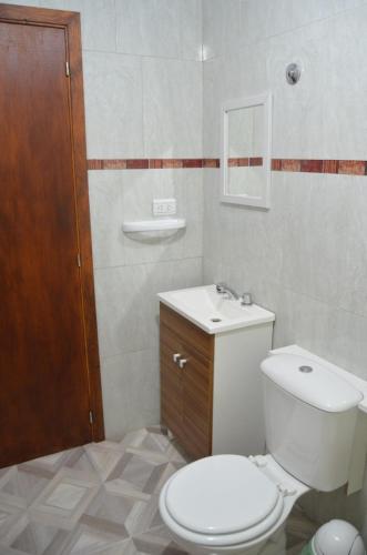 a bathroom with a white toilet and a sink at TAID in Esquel